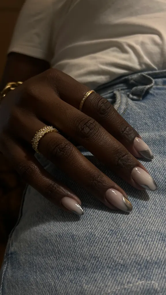 Main aux ongles amande beige nacré, reflets argentés